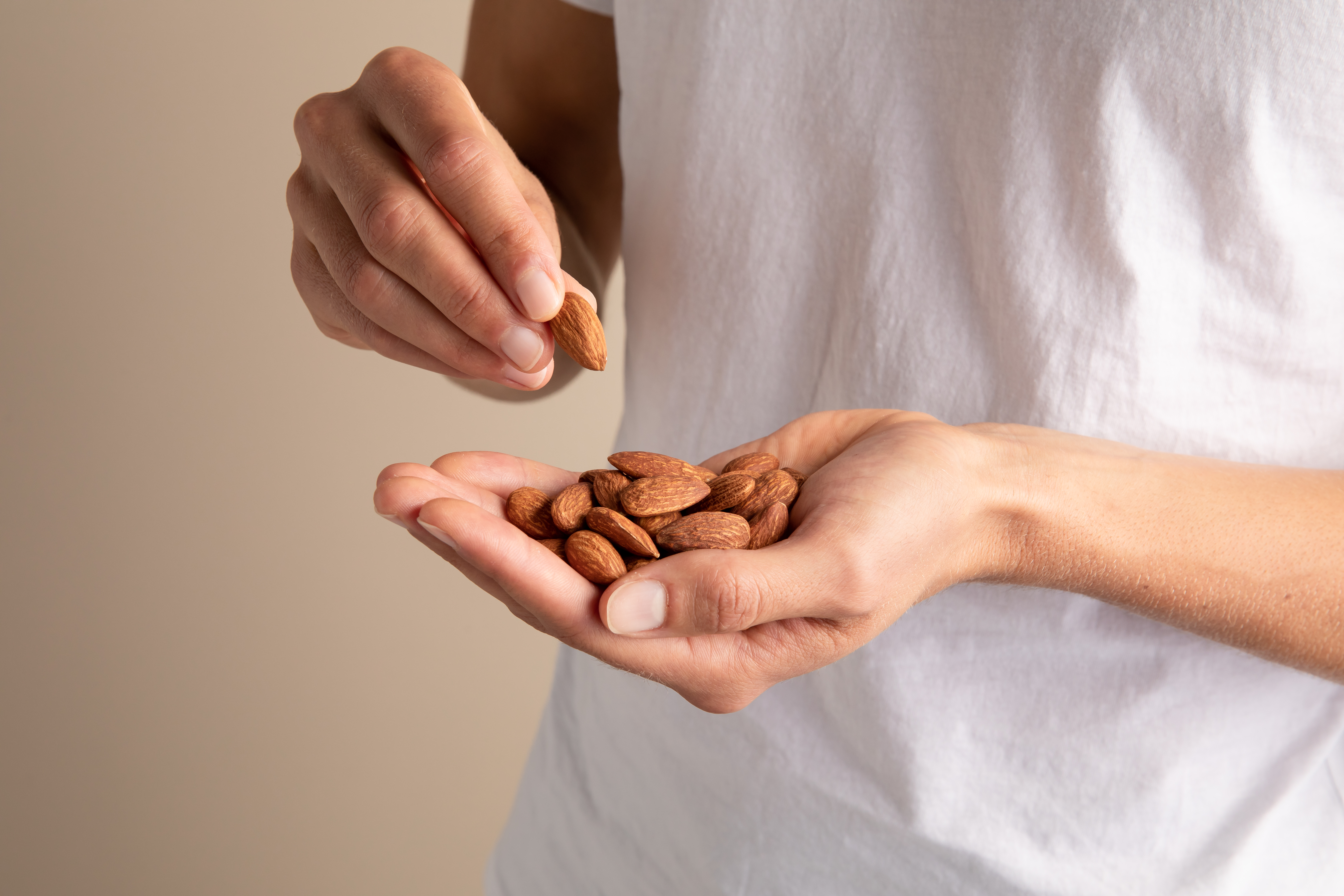 Model holding handful of almonds